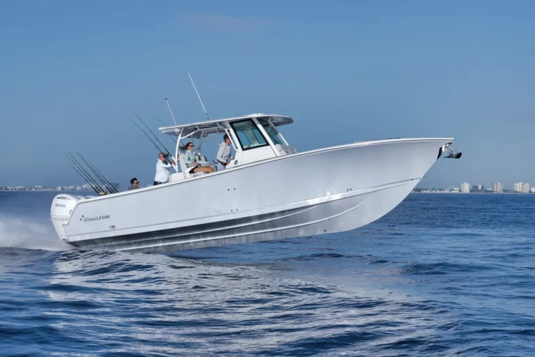 White sport boat speeding on blue water with several people fishing from the deck, skyline in the distance