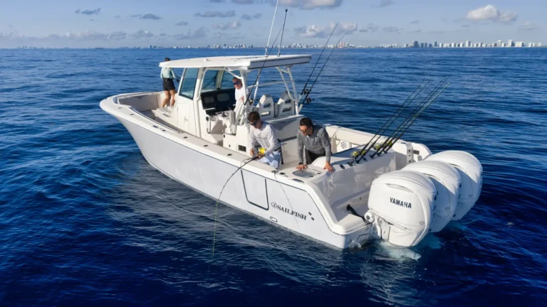 White sportfishing boat with several anglers on deck fishing in the blue ocean, city skyline on the horizon.