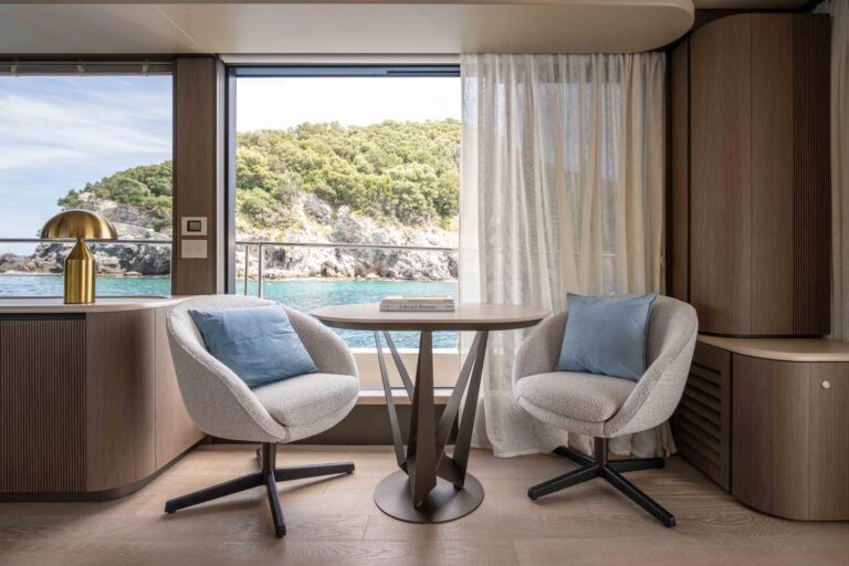 two chairs and table next to large sliding glass door