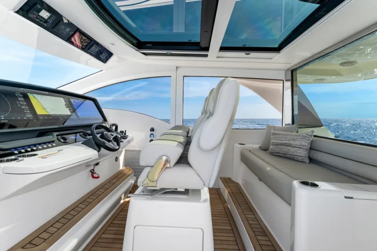 Luxurious boat cockpit with captain's chair, large navigation display, and ocean view through windows