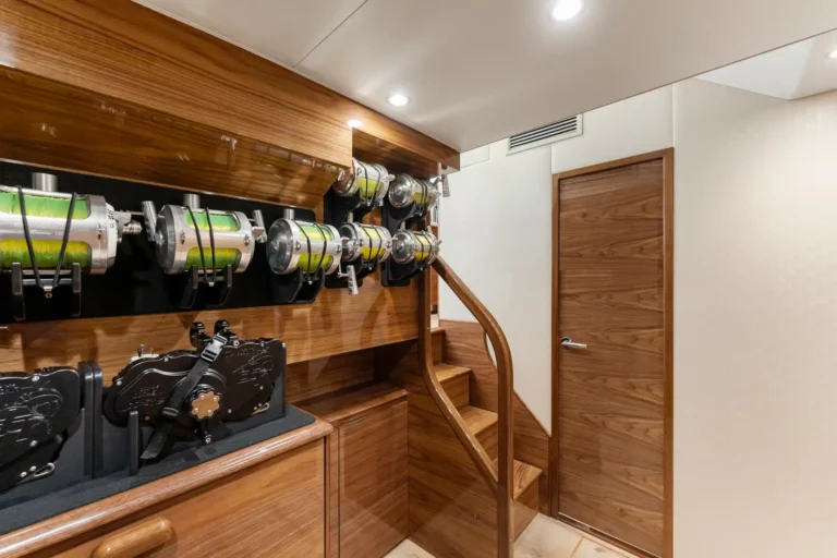 Wood-paneled storage area with multiple wall-mounted reels holding bright green cords along a staircase.