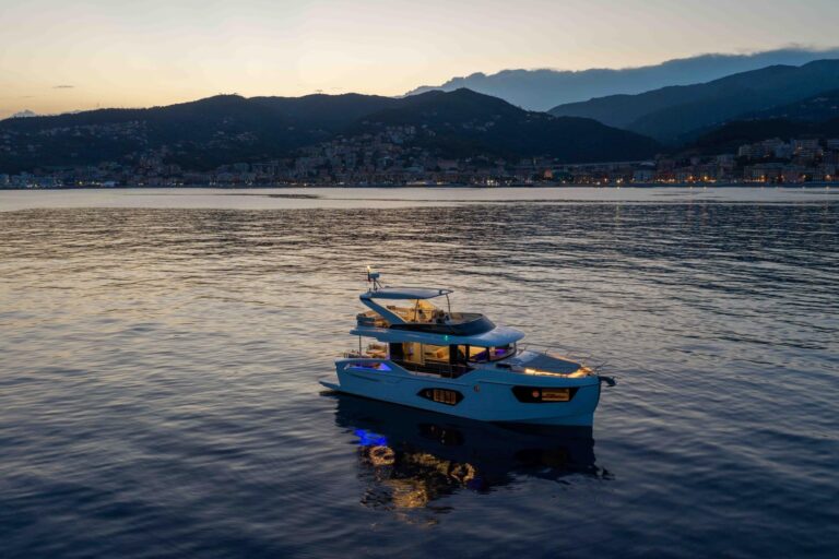 navetta 50 lit up at night with mountains in background