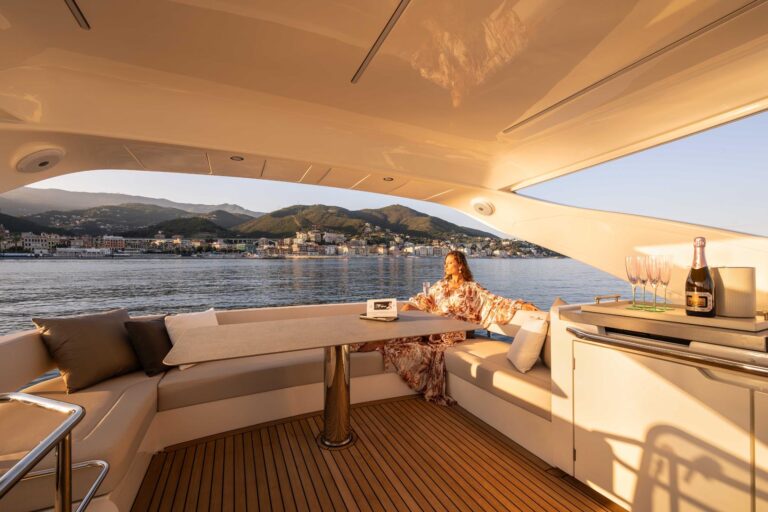 woman enjoying a glass of champagne at sunset on the flybridge